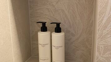 Un estante de baño con dos productos de Marie Danielle: uno etiquetado como champú y el otro como gel de ducha.