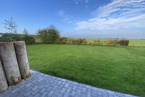 Ein gepflegter Rasen mit einem gepflasterten Weg und Blick auf die Landschaft.