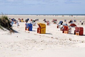 Een strand met talloze kleurrijke strandhutten en een zandrijke kustlijn.