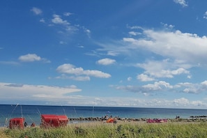 Una platja amb cabanes vermelles i un cel serè.