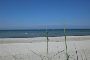 Een strand met helderblauw water en een zandstrand.