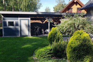 A modern house with a covered garage, a well-maintained lawn, and neatly trimmed bushes. - in the Stolkos holiday home (Trassenheide)