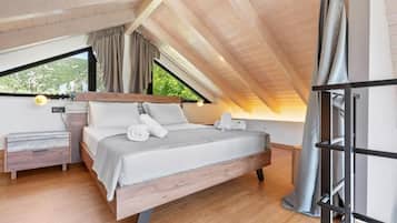 A bedroom with a wooden ceiling, a bed with white bedding, a nightstand, and a window with curtains.