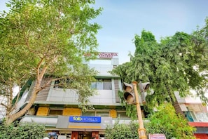 Un edificio de varios pisos con un letrero que dice 'fabHOTELS' y otro letrero que dice 'Hotel Chandan'.