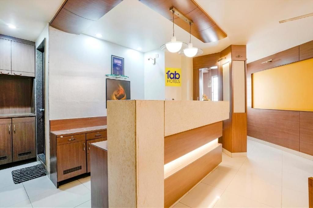 A hotel reception area with a reception desk, wooden cabinets, and a sign for 'fab hotels'.