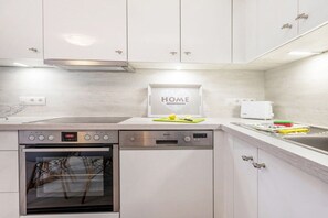 A modern kitchen with stainless steel appliances, a dishwasher, and a built-in oven. - Holiday apartment Vogelhaus (Binz)