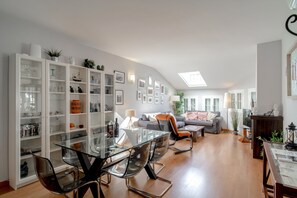 A spacious living area with a glass dining table, a grey sofa, and a bookshelf filled with various items. - House in Nerja Near Playa Burriana Beach (Nerja)