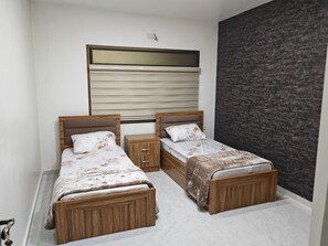 Un dormitorio con dos camas, una mesita de noche y un espejo grande sobre las camas.