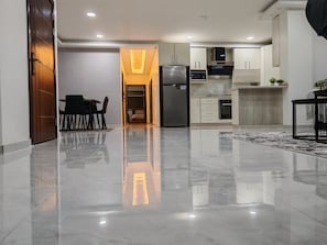 Una cocina moderna con refrigerador, microondas, horno y armarios.