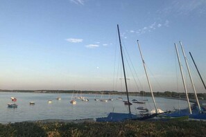 Ein Yachthafen mit mehreren Segelbooten, ruhigem Wasser und blauem Himmel.