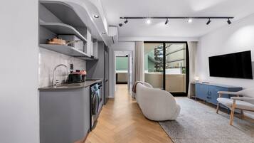 Una cocina moderna con electrodomésticos integrados, un comedor con televisor de pantalla plana y vistas al exterior.