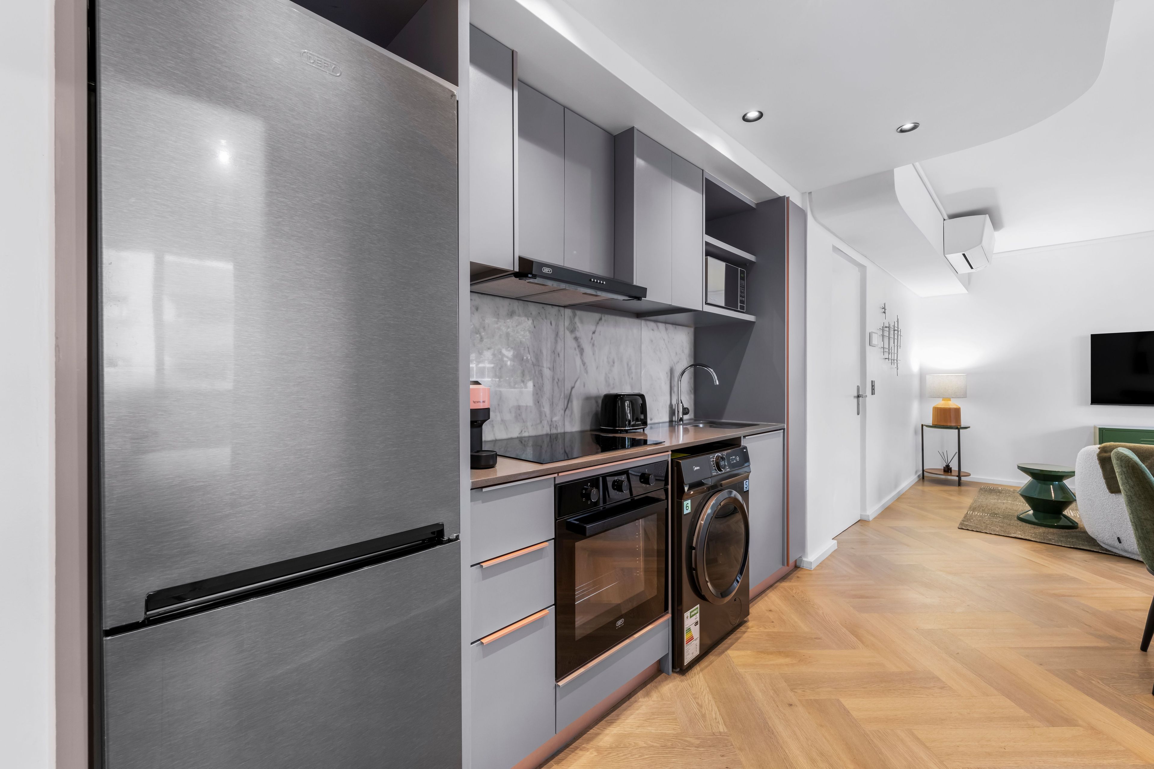 A modern kitchen with stainless steel appliances, a built-in oven, and a microwave.