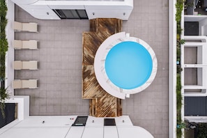 A rooftop pool area with a circular pool, seating, and a wooden deck. - Apartments by Morea Sea Point (Cape Town)