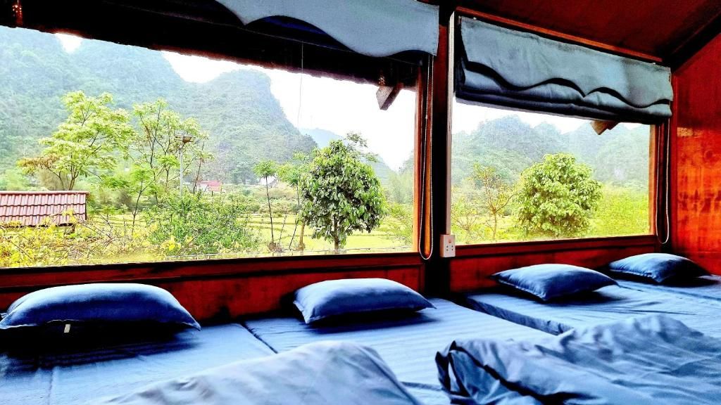 Habitació amb llit i finestra que ofereix vistes a un paisatge de muntanya.