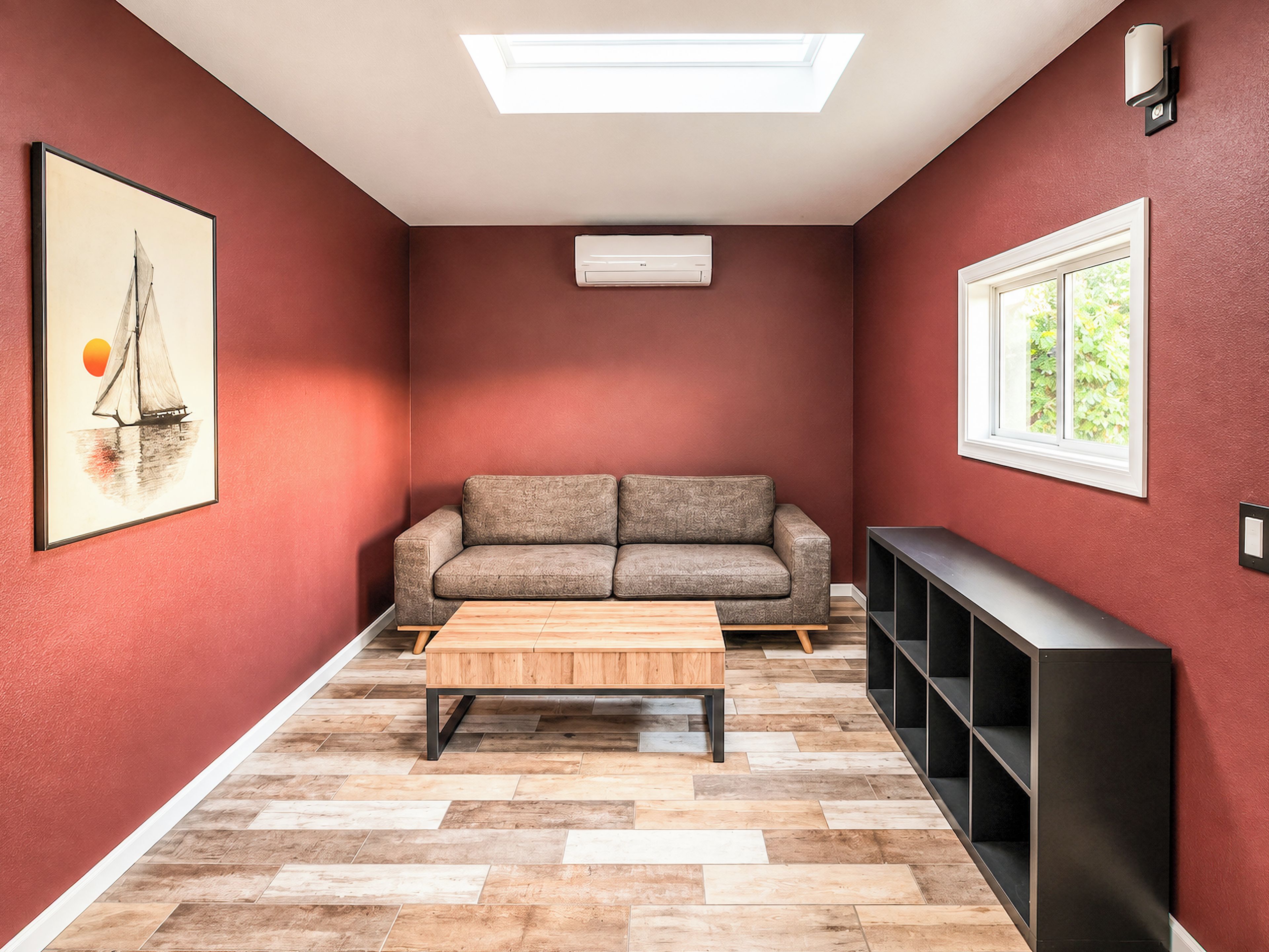A room with a sofa, a coffee table, a TV stand, a skylight, and a framed picture on the wall.