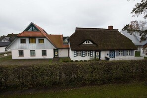 Ein traditionelles Gebäude mit einem steilen Dach und einer weißen Fassade.
