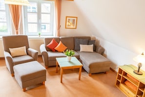 Ein Wohnzimmer mit einer Sofagarnitur, einem Couchtisch und einer Lampe.