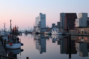 A marina with boats docked, a building with a crane, and a clear sky. - in the heart of the old town (Heiligenhafen)