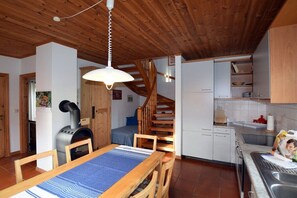A compact kitchen with a dining area, wooden ceiling, and a built-in stove. - ||-------------------1 in the House of the Wren------------------|| (Prerow)
