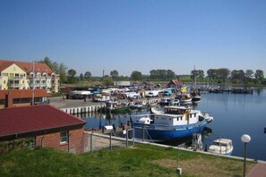 Ein Yachthafen mit vertäuten Booten, ein Gebäude mit rotem Dach und ein klarer Himmel.