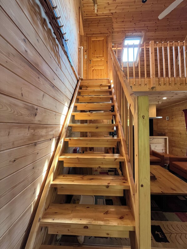 A wooden staircase with a handrail leading to a second-floor landing.