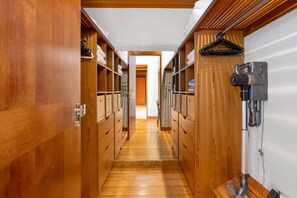 A narrow hallway with wooden lockers and a vacuum cleaner on the right. - Far Pavilions - An Intimate Bali-style Haven (Port Douglas)