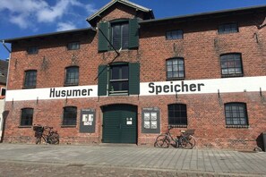 A brick building with two signs reading 'Husumer' and 'Speicher'. - Relaxation under a thatched roof (Bordelum\/Sterdebüll)