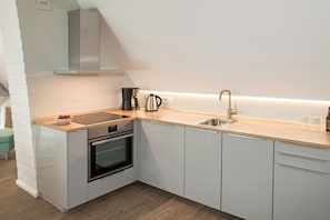 A modern kitchen with a built-in oven, a coffee maker, and a sink. - Holiday apartment with 1 bedroom (Gelting)