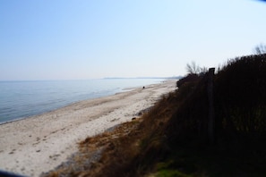 A beach with a sandy shore and a fence on the right. - Holiday apartment with 1 bedroom (Gelting)