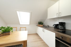 A compact kitchen with a window, a dining table, and a coffee maker. - Holiday apartment in Rade with barbecue (Rade)