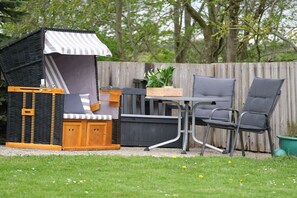 A cozy outdoor seating area with a wicker playhouse, a table, and two chairs. - Holiday apartment in Rade with barbecue (Rade)