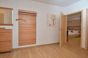 Ein Schlafzimmer mit einem Holfischschrank, einem Bett und einem Bild an der Wand.