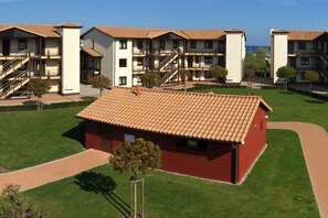 Un hotel amb edificis de diverses plantes, un edifici vermell al centre i un cel serè.