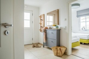 A hotel room with a bed, a bedside table, a mirror, a wardrobe, and a door. - Holiday apartment with 2 bedrooms (Zingst)