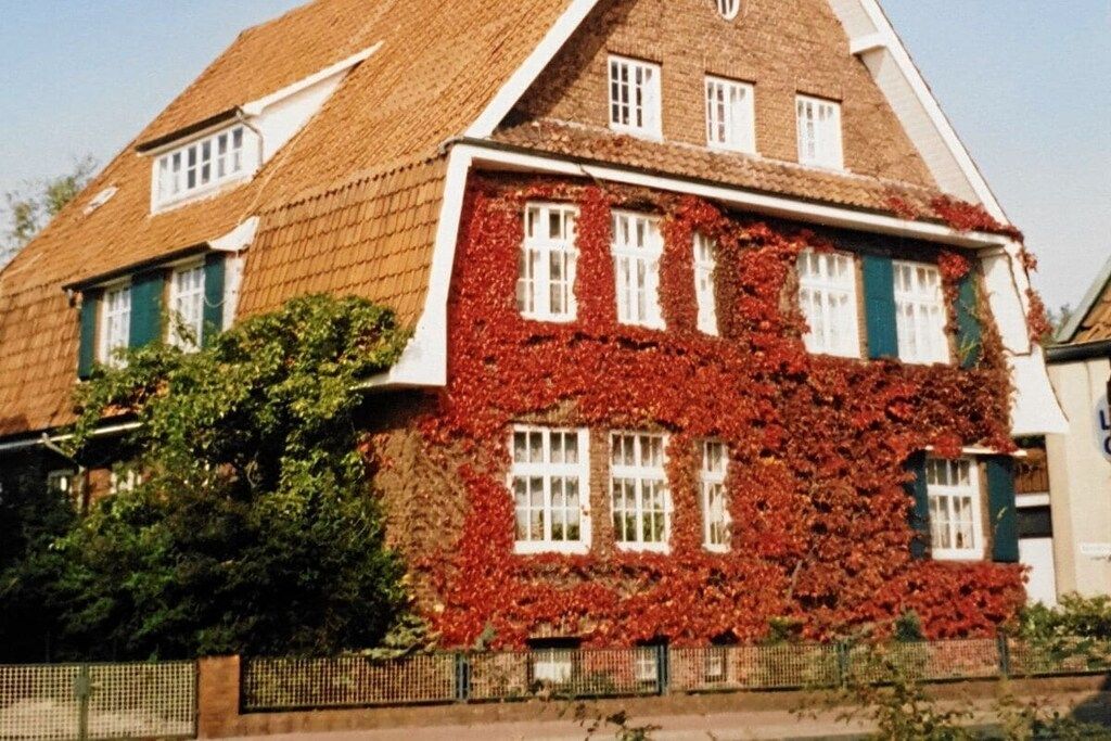 Un edificio tradicional con techo inclinado, múltiples ventanas y fachada de ladrillo.