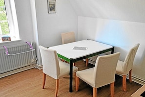 Ein Essbereich mit einem Tisch, vier Stühlen, einem Heizkörper und einem Fenster mit Blick.