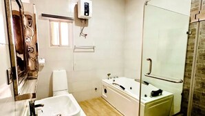 Une salle de bain moderne avec un lavabo blanc, une douche en verre et un miroir.