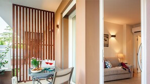 Um espaço de estar moderno com área de jantar, sofá e luminária fixada na parede.