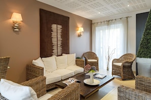 A modern living room with a sofa, two armchairs, a coffee table, and a decorative wall piece. - Breton Alcove Stay for Six (Cancale)