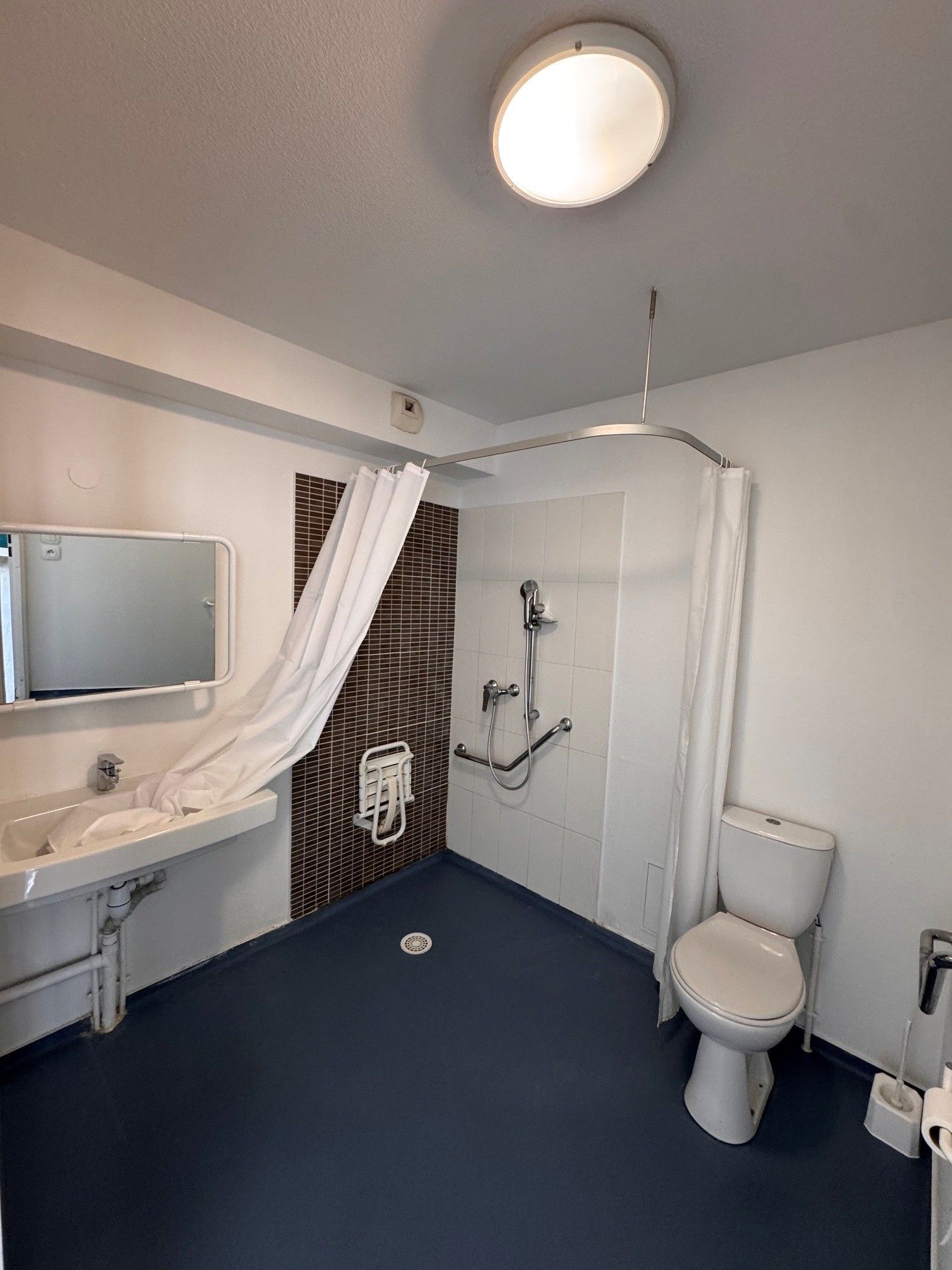 A bathroom with a shower, toilet, and sink.
