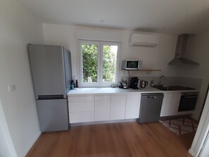 A compact kitchen with a refrigerator, microwave, and sink. - Spacious, fully equipped house surrounded by greenery, with a pool and a wood stove—perfect for families! (Cestas)