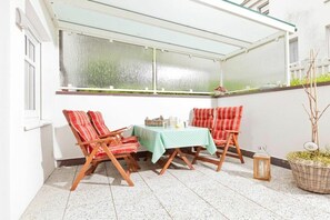 Ein Eckzimmer mit Tisch und Stühlen, einem Fenster mit Blick und einer Laterne auf dem Boden.