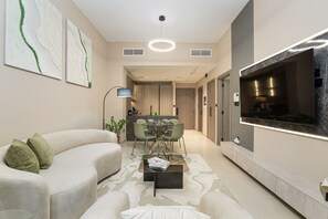 Ein modernes Wohnzimmer mit einer Couch, einem Essbereich und einem an der Wand befestigten Fernseher.