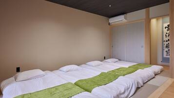 Una habitación de hotel con una cama grande, piso de madera y aire acondicionado instalado en la pared.