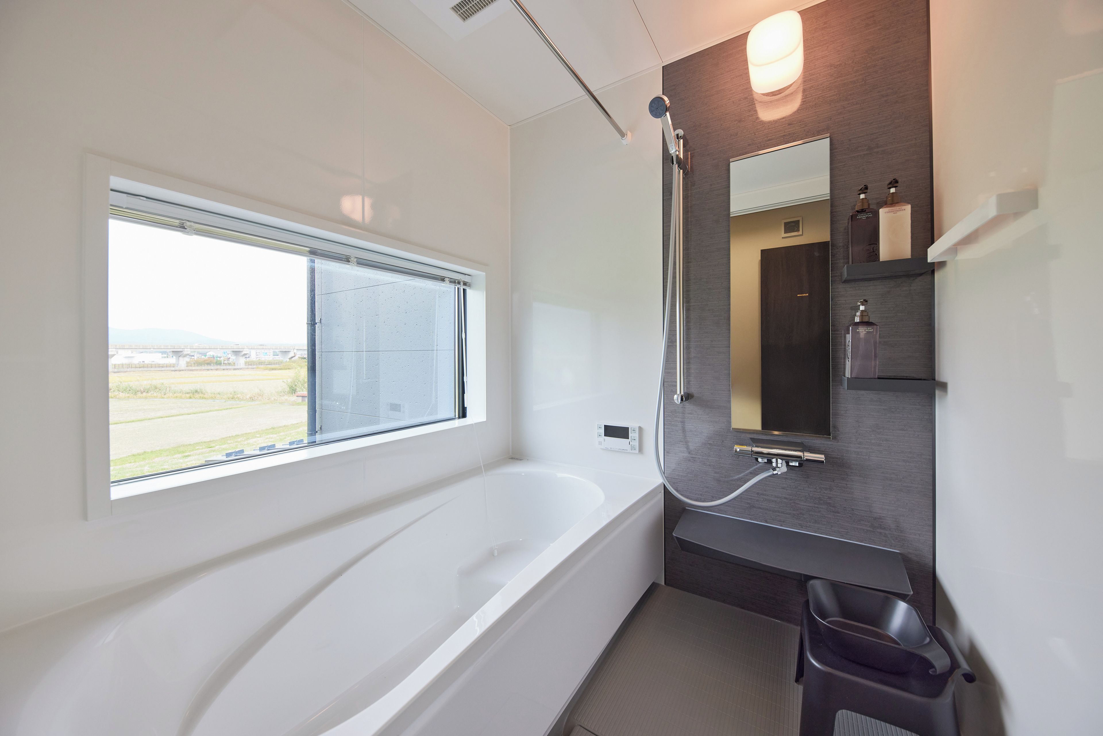 A modern bathroom with a large bathtub, a window, and a shower.