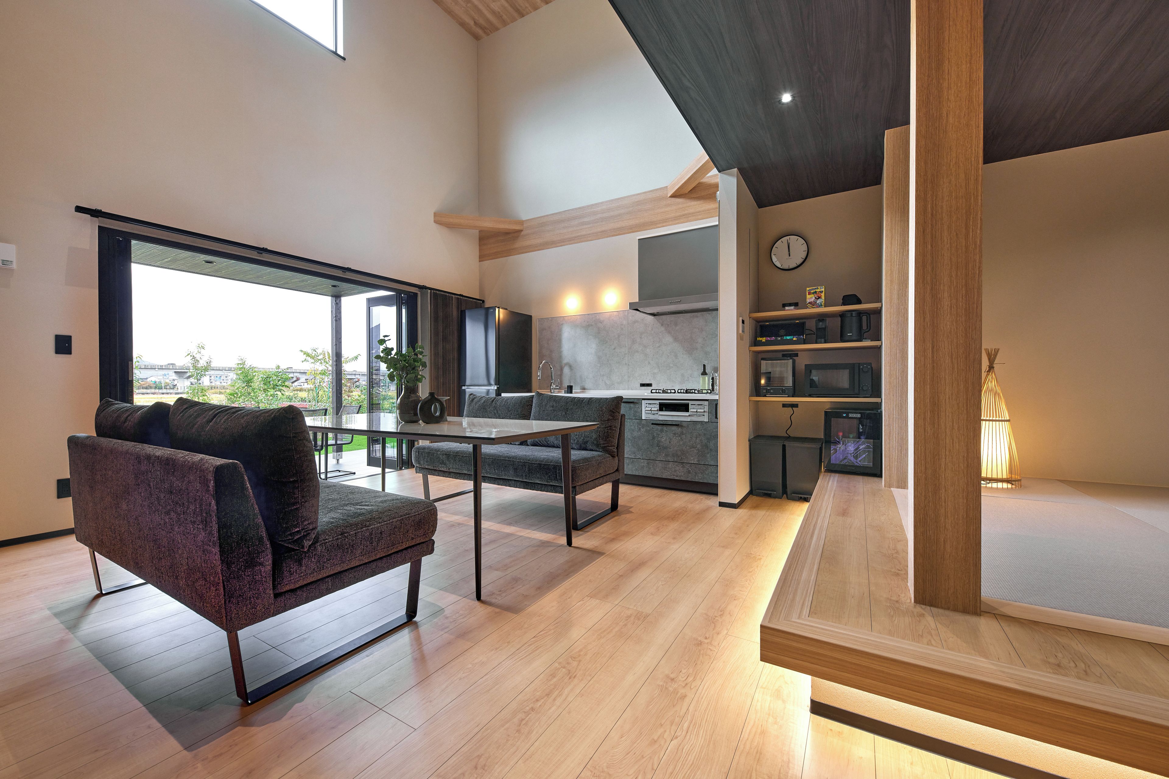 A modern interior with a sofa, dining table, and kitchen area.