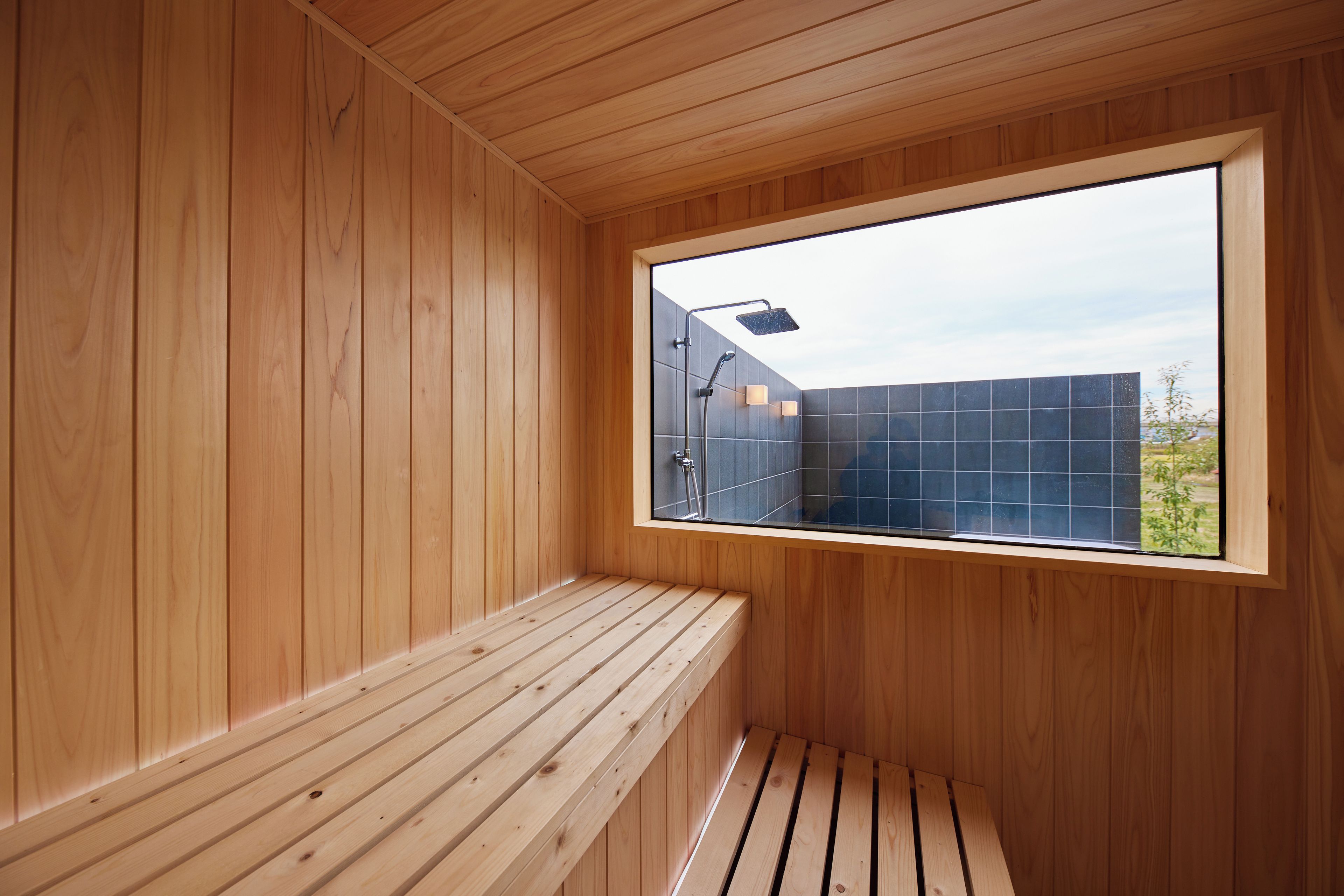 A sauna room with wooden walls and a bench.