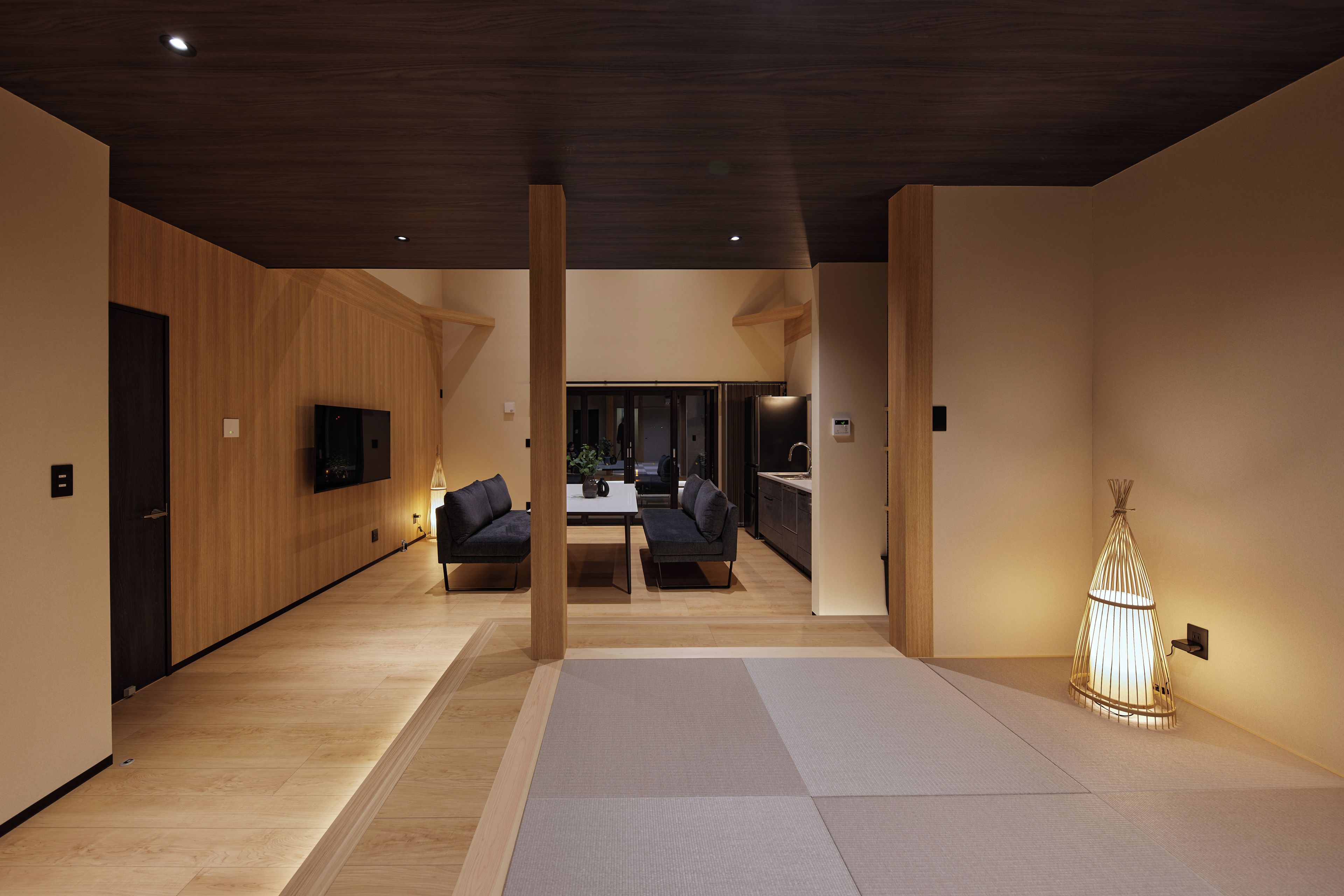 A modern interior with a wooden floor, a dining area, and a kitchen.