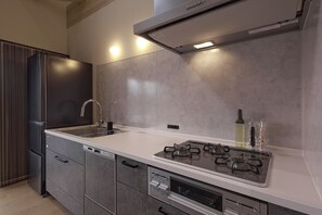 A modern kitchen with a built-in dishwasher, a stainless steel range, and a double sink.
