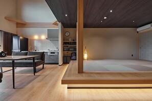 Un interior moderno con comedor, cocina y un espacio con esteras de tatami.